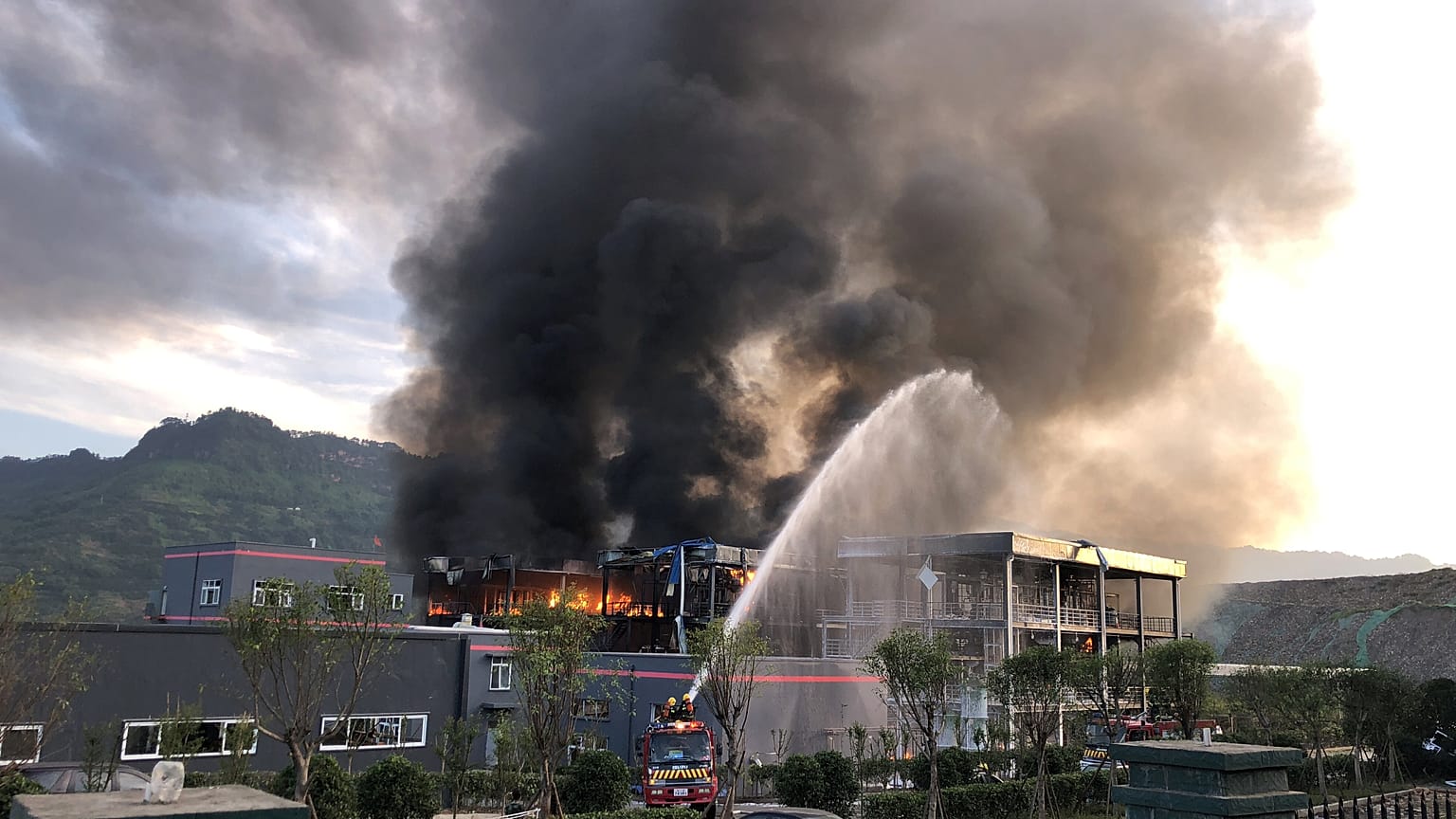 Wasserfontäne von Feuerwehr auf riesige Rauchwolke
