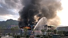 Wasserfontäne von Feuerwehr auf riesige Rauchwolke