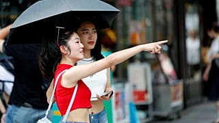 Deux jeunes femmes s'abritent du soleil au Japon durant une canicule