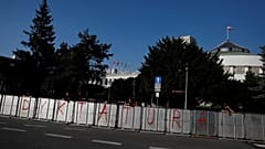 Police stands near a barrier with the word 'dictatorship' written on it