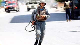 Ein afghanischer Polizist eilt zu einem der Orte, wo Feuer zu sehen ist