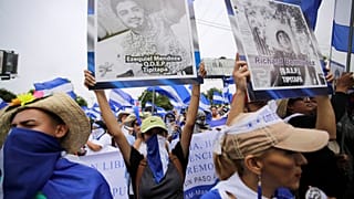 Tüntetők a zavargások során megölt diákok képeivel a kezükben Nicaraguában