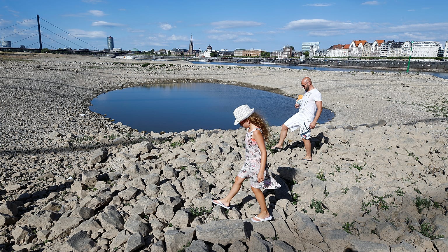 Una familia juega en el lecho seco del río Rin, en Düsseldorf, Alemania
