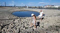 Una familia juega en el lecho seco del río Rin, en Düsseldorf, Alemania