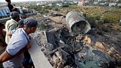 فلسطينيون ينظرون إلى الدمار الذي سببه القصف الإسرائيلي ببلدة المغراقة بغزة