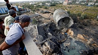 فلسطينيون ينظرون إلى الدمار الذي سببه القصف الإسرائيلي ببلدة المغراقة بغزة