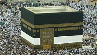 شاهد: رجل يصعد إلى باب الكعبة ولباس الإحرام يقع عنه