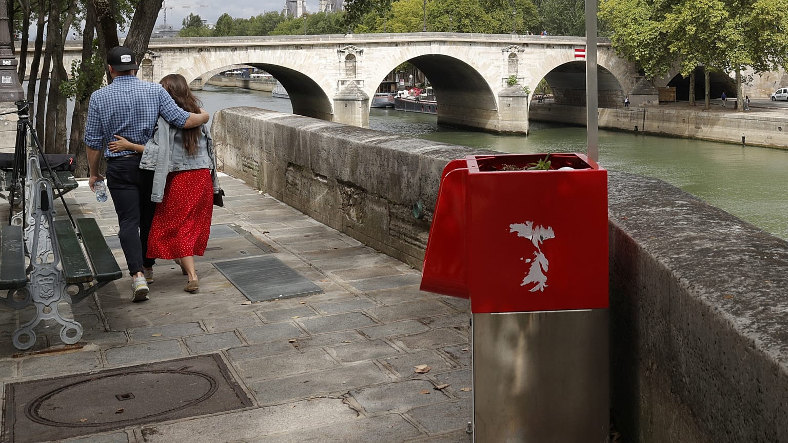 A couple walks near eco-friendly urinal on the Ile Saint-Louis