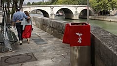 A couple walks near eco-friendly urinal on the Ile Saint-Louis