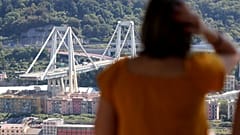 Eine Frau blickt auf die eingestürzte Brücke in Genua