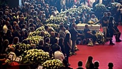 Mit Blümen geschmückte Särge bei der Trauerfeier