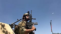 Member of the Afghan security forces keeps watch at the site of th attack