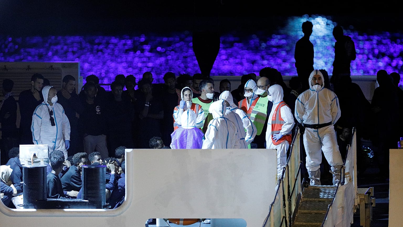 Sick migrants disembark Italian coastguard boat