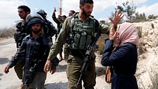 Una mujer palestina frente a un soldao israelí en la aldea de Ras Karkar