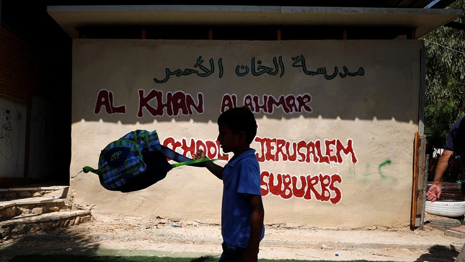 یک کودک فلسطینی در کنار مدرسه خان‌الاحمر