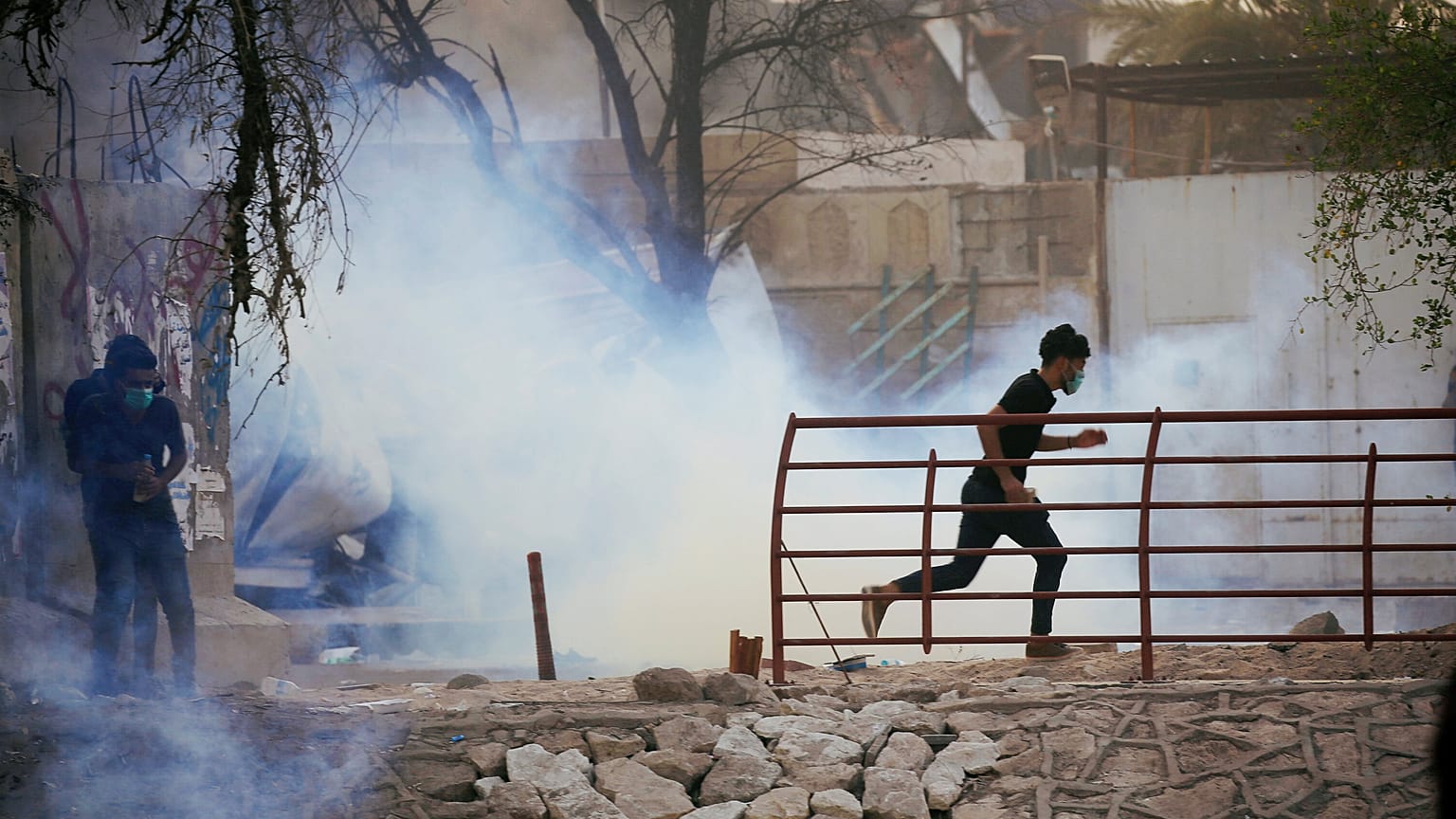 متظاهر عراقي يهرب من غاز مسيل للدموع اثناء الاحتجاجات