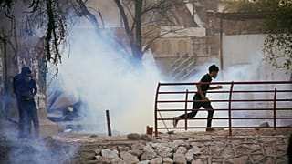 متظاهر عراقي يهرب من غاز مسيل للدموع اثناء الاحتجاجات