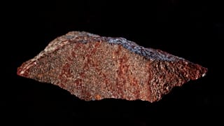 Red ochre markings on a stone flake discovered in Blombos Cave