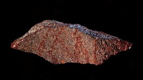 Red ochre markings on a stone flake discovered in Blombos Cave