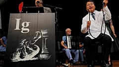 Akira Horiuchi (R) demonstrates his research at the 2018 IG Nobel ceremony.