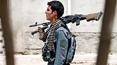 An Afghan policeman keeps watch during a battle with insurgents in Kabul.