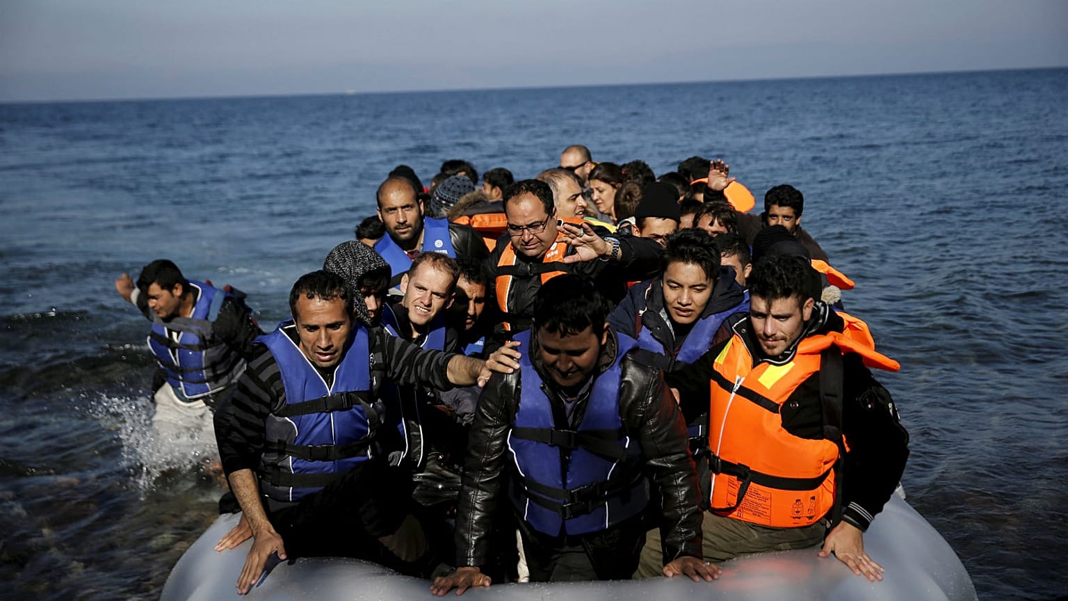 Refugees and migrants arrive on a raft on the Greek island of Lesbos.