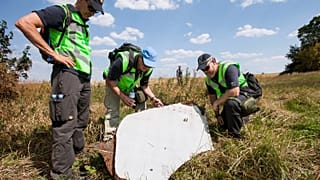 Dutch and Australian officers inspect the site of the MH17 crash.