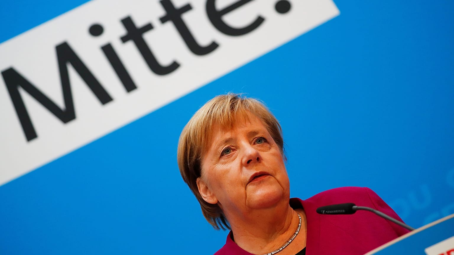 Angela Merkel bei einer Rede; im Hintergrund das Wort "Mitte"