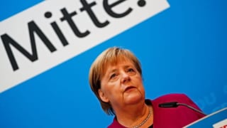 Angela Merkel bei einer Rede; im Hintergrund das Wort "Mitte"