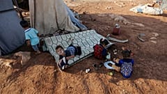 Newly displaced Syrian children play after their arrival to a camp in Idlib