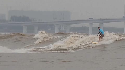 Surfers from around the world gather to ride tidal bores of the Qiantang River