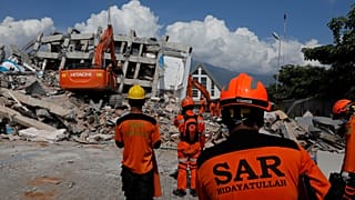 Rescuers on Sulawesi Island, Indonesia work in the rubble of a hotel