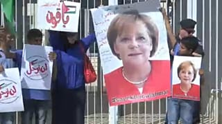 أهالي خان الأحمر يرفعون صور المستشارة الألمانية ميركل