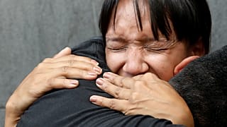 Mourners react outside National Intelligence Service building in Caracas
