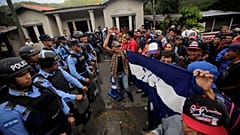 Migrants are confronted by police at the Honduras-Guatemala border