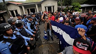 Migrants are confronted by police at the Honduras-Guatemala border