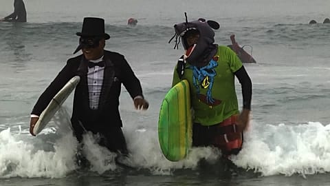 Surfistas disfrazados festejan Halloween sobre las olas en Newport Beach