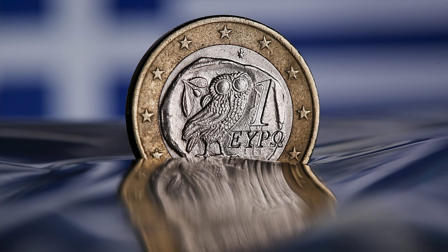 FILE PHOTO: Euro coins are seen in front of a displayed Greece flag in this picture illustration, June 29, 2015. REUTERS/Dado Ruvic/File Photo
