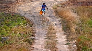Un niño transporta agua en Papúa Nueva Guinea