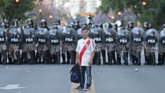 Adepto do River Plate diante de um cordão da polícia argentina