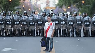 Adepto do River Plate diante de um cordão da polícia argentina