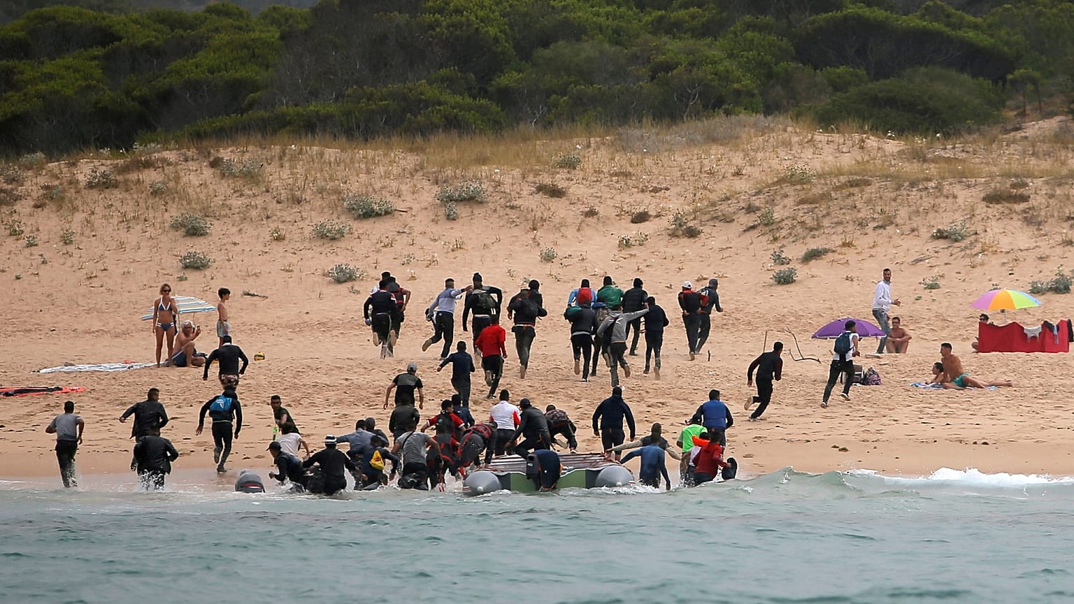 Migrants on Del Canuelo beach, after they crossed the Strait of Gibraltar