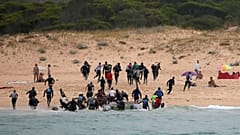Migrants on Del Canuelo beach, after they crossed the Strait of Gibraltar