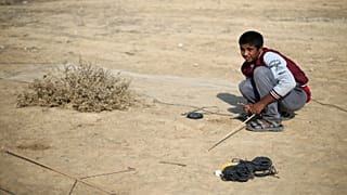 الفلسطيني حمزة أبو شلهوب يحاول اصطياد طيور مغردة في أطلال مطار غزة الدولي