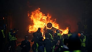 Égő autó a december elsejei párizsi zavargásba torkolló demonstráción