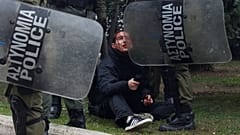 Ein verletzter Demonstrant wird von griechischen Polizisten festgehalten.