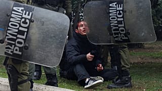 Ein verletzter Demonstrant wird von griechischen Polizisten festgehalten.