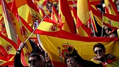 People sing the national anthem at a rally for national unity in Madrid.