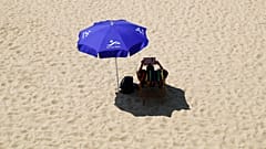 Ein Mann liegt an einem Strand am Berliner Wannsee