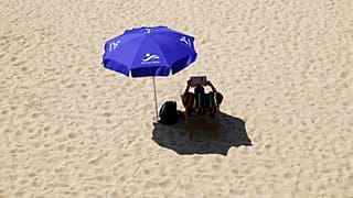 Ein Mann liegt an einem Strand am Berliner Wannsee